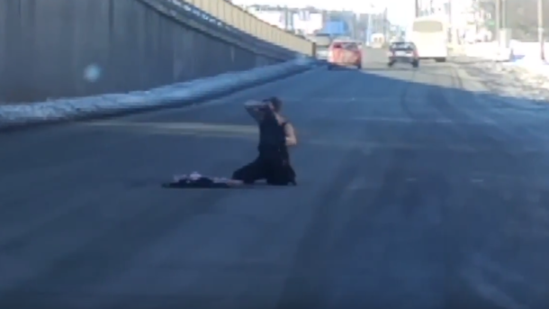 В Киеве водителей напугала женщина, которая ползала и срывала с себя одежду